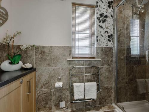 ein Bad mit einer Dusche und einem Waschbecken in der Unterkunft 3 Bed in Cirencester HIC02 in South Cerney