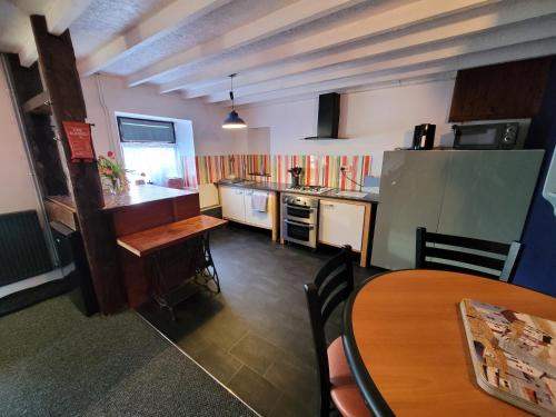 eine Küche mit einem Tisch und einem Kühlschrank und einem Tisch in der Unterkunft Charming pet friendly 2 bedroom cottage, close to Narberth & local beaches, friendly animals on our smallholding in Pembrokeshire