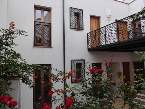 un edificio blanco con flores rojas y balcón en Casa de la escalera 1ª D, en Córdoba