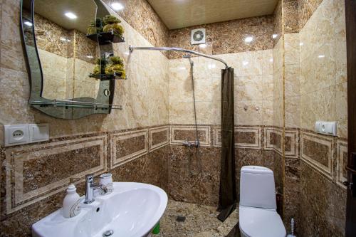 a bathroom with a sink and a shower and a toilet at Cozy Apartment on Kostava in Tbilisi City