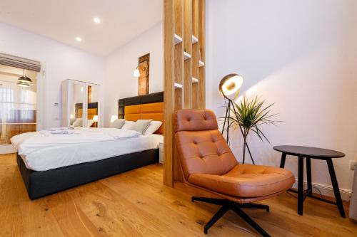 a bedroom with a bed and a chair and a table at The Chic One, Unirii Square View in Timişoara