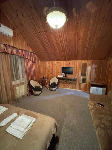ein Schlafzimmer mit einem Bett und zwei Stühlen darin in der Unterkunft Готельний комплекс Samson in Pryluky