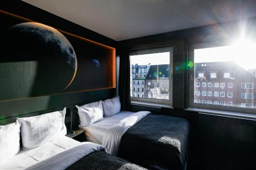 a room with two beds and a window at Sleephotels Cosmos in Hamburg