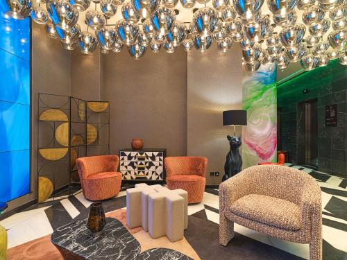 a living room with chairs and a chandelier at NYX Esperia Palace Hotel Athens by Leonardo Hotels in Athens
