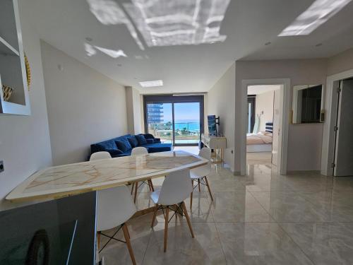 ein Wohnzimmer mit einem Tisch, Stühlen und einem Sofa in der Unterkunft Konak Tower Seaside mahmutlar in Alanya
