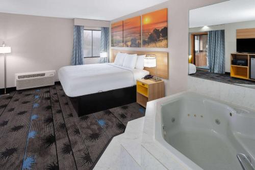 a hotel room with a bed and a tub at Days Inn by Wyndham Wooster in Wooster