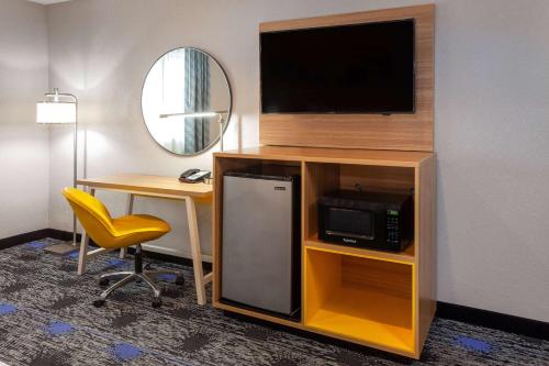 a hotel room with a desk and a tv and a room at Days Inn by Wyndham Wooster in Wooster