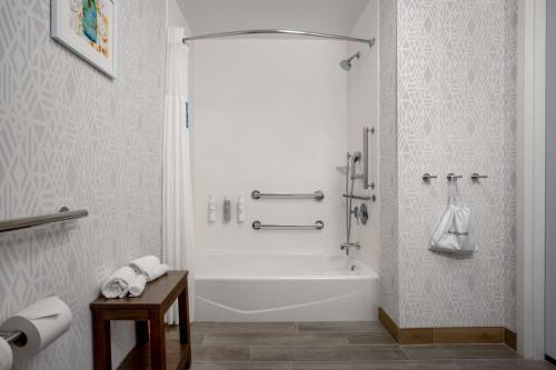 uma casa de banho branca com uma banheira e um lavatório em Hampton Inn & Suites Muncie em Muncie