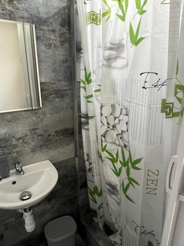 uma casa de banho com um lavatório, um WC e uma cortina de chuveiro. em Lilla motel em Hegyeshalom