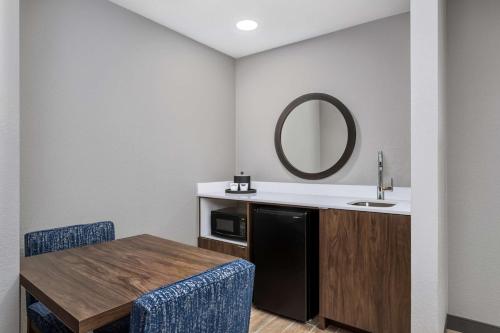 ein Badezimmer mit einem Tisch, einem Waschbecken und einem Spiegel in der Unterkunft Hampton Inn & Suites Richmond in Richmond