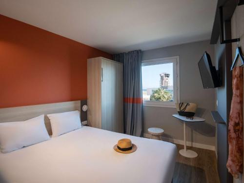 a bedroom with a bed with a hat on it at ibis budget Nice Aeroport in Nice