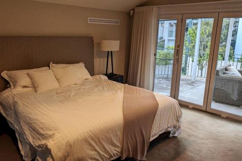 een slaapkamer met een bed en een glazen schuifdeur bij Tranquil Escape at Balmoral Beach in Sydney