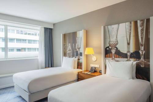 a hotel room with two beds and a window at DoubleTree by Hilton Wroclaw in Wrocław