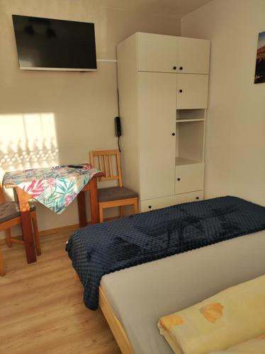 a bedroom with a bed and a cabinet and a chair at DG EWA w Polańczyku in Polańczyk