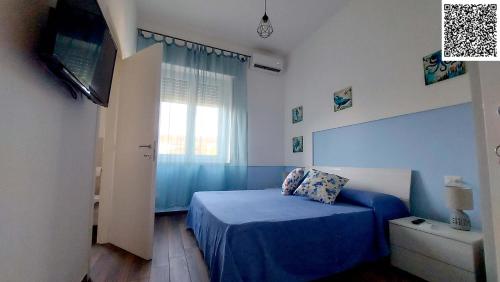 a bedroom with a blue bed and a television at The Other House B&B in Formia