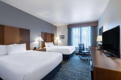 a hotel room with two beds and a flat screen tv at La Quinta by Wyndham Morgantown in Morgantown