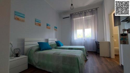 a bedroom with two beds and a window at The Other House B&B in Formia