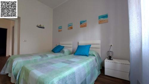 a bedroom with two beds with blue pillows at The Other House B&B in Formia