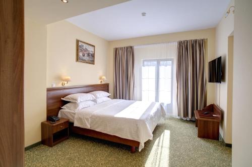 um quarto de hotel com uma cama e uma janela em Hotel Central em Ploieşti