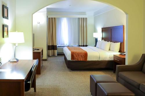Habitación de hotel con cama y sofá en Comfort Inn & Suites, en Odessa