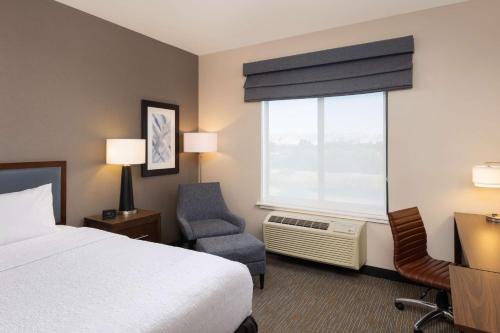 Habitación de hotel con cama, silla y ventana en Hampton Inn San Jose Cherry Ave, CA, en San José