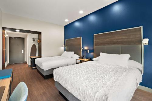 a hotel room with two beds and a blue wall at Tru By Hilton Santee in Santee