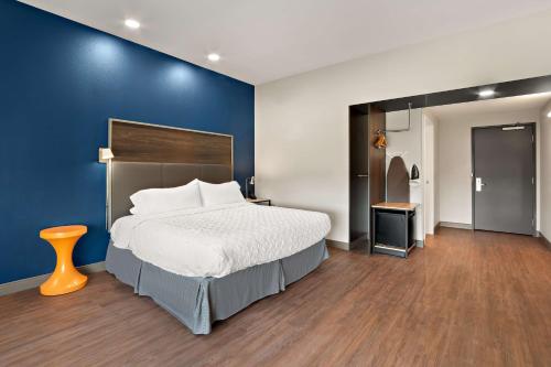 a bedroom with a large bed and a blue wall at Tru By Hilton Santee in Santee