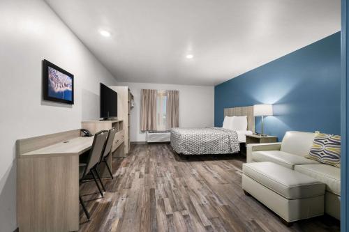 a small hotel room with a bed and a desk at WoodSpring Suites Dearborn Detroit in Dearborn