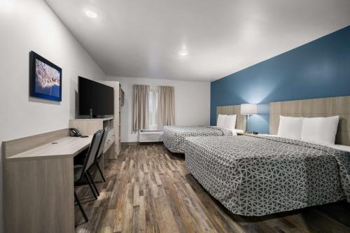 Habitación de hotel con 2 camas y escritorio en WoodSpring Suites Dearborn Detroit en Dearborn