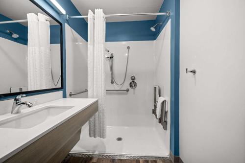a bathroom with a sink and a shower at WoodSpring Suites Dearborn Detroit in Dearborn
