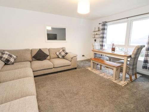 a living room with a couch and a table at 22 Moray Place in Fort William