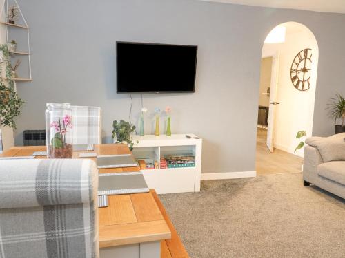 a living room with a flat screen tv on a wall at 22 Moray Place in Fort William