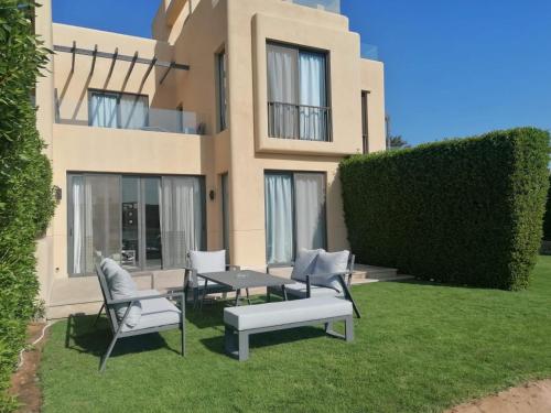 a house with chairs and a table in the yard at Luxury 3BR Townhouse, Tawila, El Gouna, Lagoon & Pool access in Hurghada