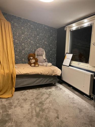 dos ositos de peluche sentados en una cama en un dormitorio en House by the lake in central Jokkmokk, en Jokkmokk