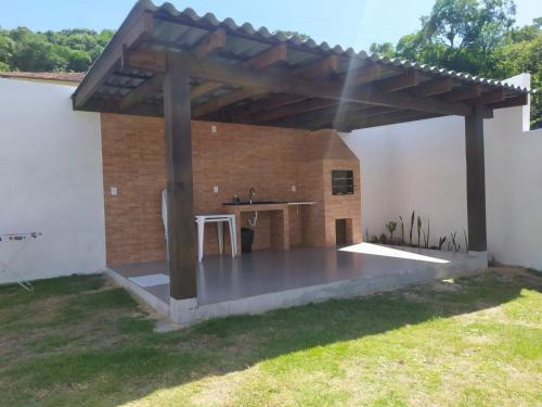 an outdoor kitchen with a wooden pergola at Casa Excepcional na Praia Brava - Florianópolis in Florianópolis
