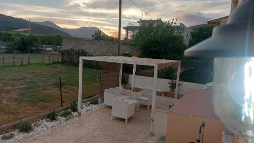 a patio with a gazebo and two white chairs at The Other House B&B in Formia