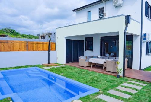 a backyard with a swimming pool and a house at Villa Idylle quatre etoiles in Rivière