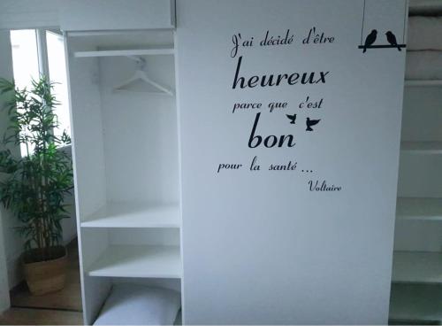 an empty shelf with a wall with a quote on it at Vue Montagne - Appt Cosy et calme - Netflix - Fibre in Grenoble