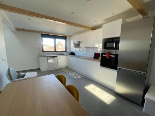 a large kitchen with a wooden table in a room at Grand Duplex Argenté 3 chambres à 20min de Paris in Argenteuil