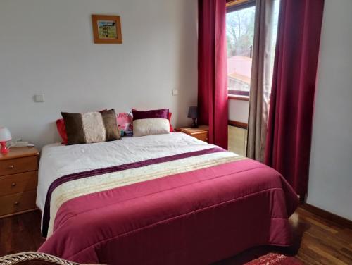 1 dormitorio con 1 cama con cortinas rojas y ventana en Espinho Sweets Suites Martinho, en Espinho