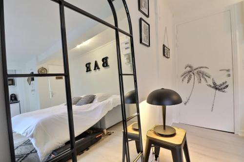 1 dormitorio con cama, mesa y espejo en O'bistrot Troyen - charme secteur piéton Mon Groom, en Troyes