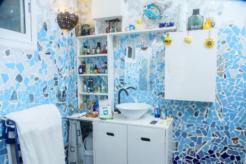 La salle de bains est pourvue de carrelage bleu et blanc et d'un lavabo. dans l'établissement Loft Keur Bibou, à Dakar