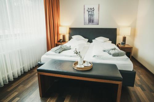 a hotel room with two beds and a table at Hotel Lauterbad in Freudenstadt