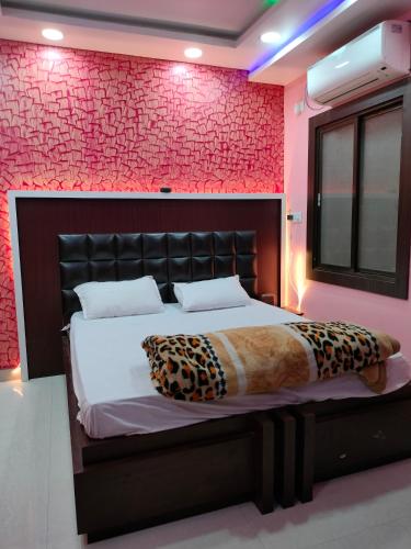 1 dormitorio con cama y pared roja en HOTEL GANESH PALACE en Aurangābād