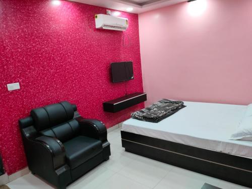 Aurangābād的住宿－HOTEL GANESH PALACE，一间卧室配有一张床和一张黑椅
