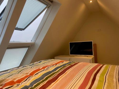 a bedroom with a bed and a flat screen tv at Eutin Wohnung Rosenstadt in Eutin