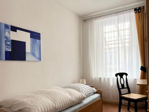 a bedroom with a bed and a chair and a window at Schlafmütze in Plauen