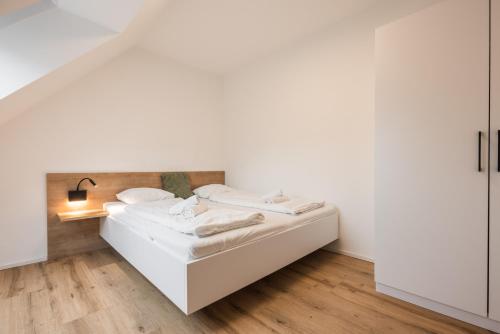 a white room with two beds in it at myQuartier Central City Suites in Innsbruck
