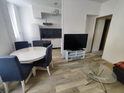 a living room with a table and a television at Appart T3 à Pamiers in Pamiers