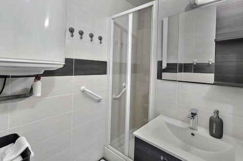 baño blanco con ducha y lavamanos en Le Voltaire | Balcon | Mon Groom Troyes, en Troyes